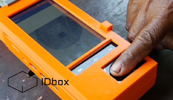 Close-up of a person’s finger pressing a solar-powered IDbox to create personal identification..